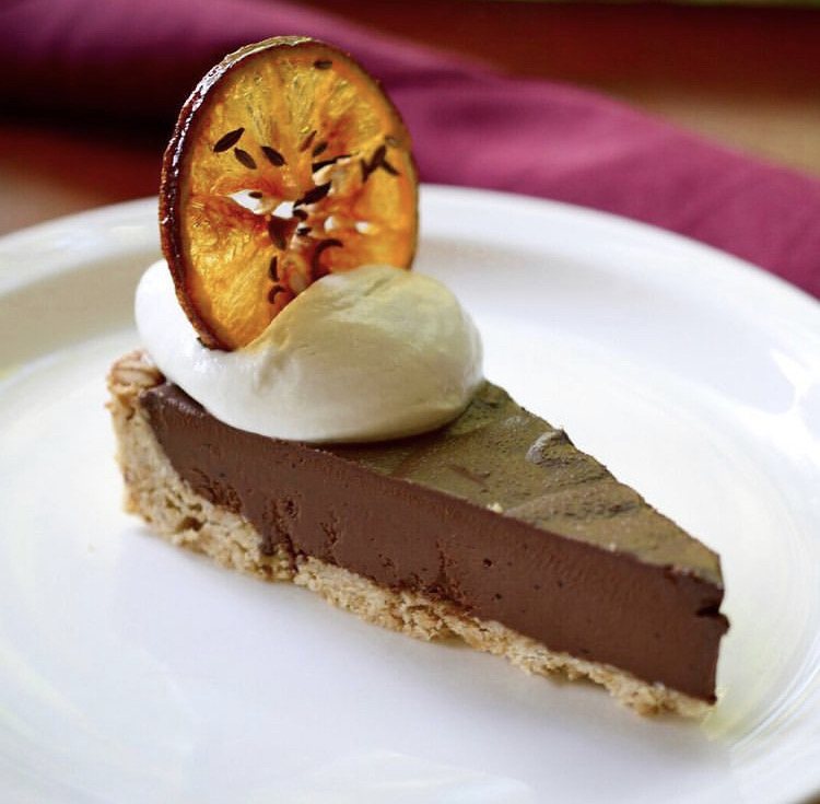 Chocolate tart with whipped cream and candied orange